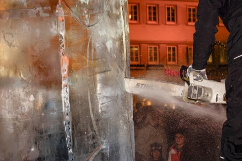 An ice sculpture is being created: ice carving street action as part of the long shopping night in