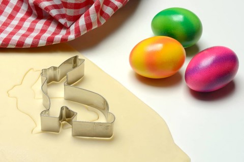 Rolled dough with bunny cookie cutter and easter eggs