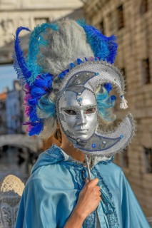 Costumed woman with traditional Venetian mask in front of the Bridge of Sighs, Carnival, Venice,