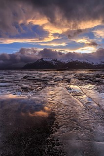 Cloudy mood and evening light over a fjord, ice floes, mountains, winter, windy, Lonsvik, East