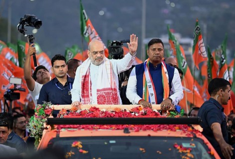 Amit Shah greets supporters during a road show of the Bharatiya Janata Party ahead of the Assam