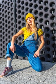 Young blonde woman wearing casual clothes dancing urban dance outdoors near a modern building