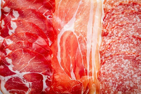 Various types of cured meats including prosciutto, salami, and other specialties are beautifully