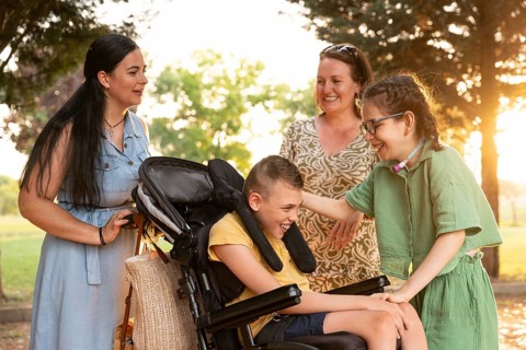 A joyful family moment with a disabled girl with a tracheostomy and a boy with cerebral palsy,