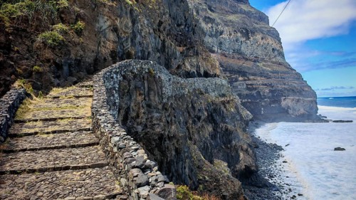Narrow stone trail, volcanic stone hiking trail along high cliffs with sea views, hiking, Marinha