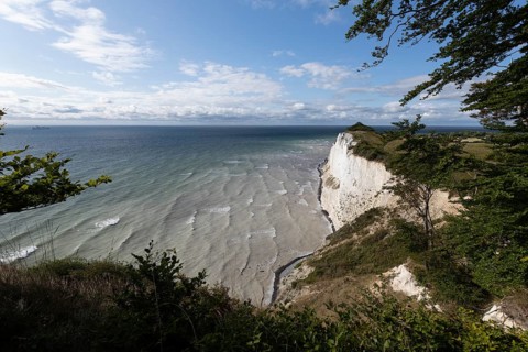 White chalk cliffs at Hundevængsfald with a view of the Baltic Sea towards Møn Lighthouse under a