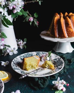 A delectable spring lemon bundt cake served on a decorative plate, complemented by vibrant blossoms