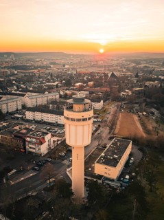 Water tower dominates the city skyline at sunset with clear sky tones, Sindelfingen, Germany