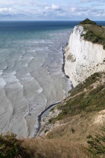 White chalk cliffs at Hundevængsfald with a view of the Baltic Sea towards Møn Lighthouse under a