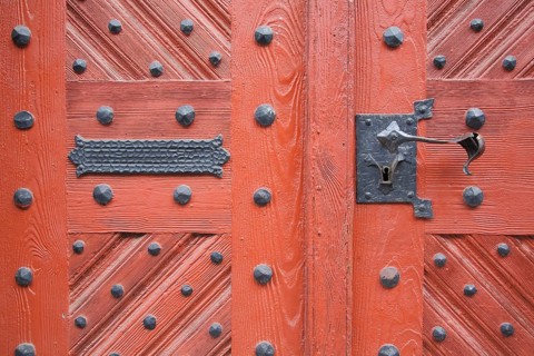 Metal fittings on red front door from town hall, rivets, mailbox slot, door handle, detail,
