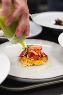 A delectable lobster dish garnished with vibrant green sauce. Fresh lobster, creamy filling, and