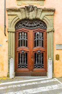 Decorated arched entrance door, historic city centre, Lucca, Tuscany, Italy