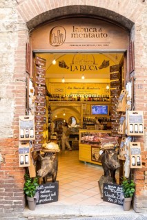 Entrance to a charcuterie shop with stuffed wild boars in front of it, historic centre of San