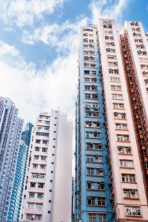 Tall residential buildings dominate the Hong Kong cityscape, showcasing vibrant architecture and