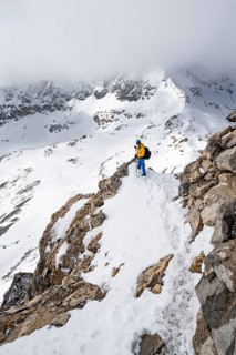Mountaineers climbing the ridge of Piz Laviner, view of wintry mountain landscape, Grisons Haute