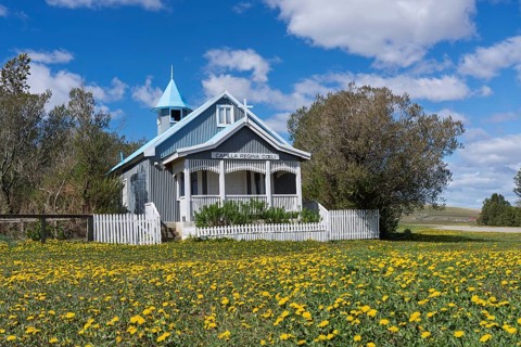Capilla Regina Coeli chapel, wooden church with corrugated iron panelling and blue tower roof,