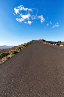 Empty country road leading uphill, Caldera, Guanapay volcano, near Teguise, Lanzarote, Spain