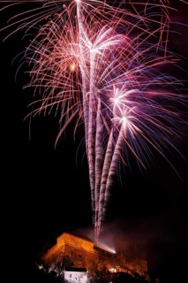 Red and blue firework rockets rise into the air and light up the dark night, New Year's Eve,