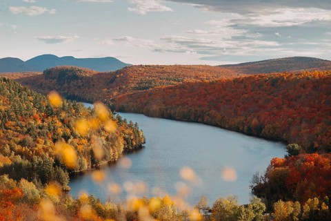 A breathtaking view of Quebec's countryside during autumn, showcasing a river winding through