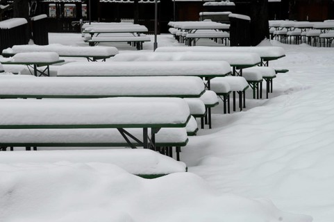 Winter in the English Garden, snow-covered beer garden tables and benches, Munich, Bavaria, Germany
