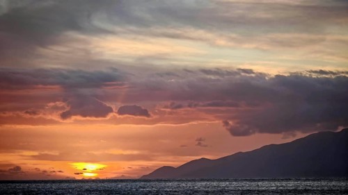 A pastel sunset over the sea and mountains with calm clouds, Mindelo, Sao Vicente, Cabo Verde, Cape
