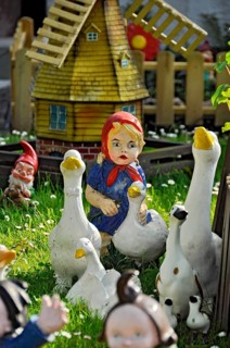 Garden gnomes from the fairy tale The Goose Maid with Geese, in a front garden on a flower meadow