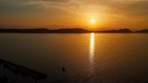 The sunset is reflected in the sea, the landscape can be seen in silhouettes, Navarino Bay, Pylos,