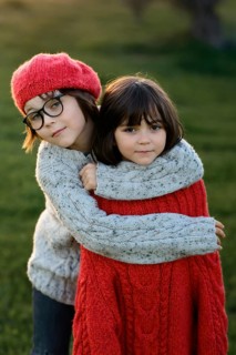 A boy and girl, siblings, warmly embrace in an autumn park setting, showcasing expressions of