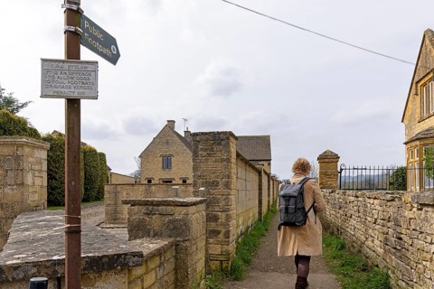 Signpost, footpath to Batsford Arboretum, woman, pedestrian, Moreton-in-Marsh, Cotswolds, England,