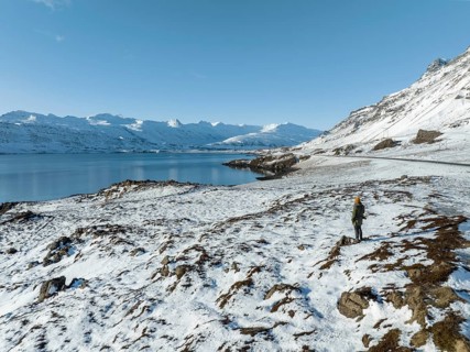 A mesmerizing winter landscape in Iceland featuring a lone adventurer exploring the snowy terrain.