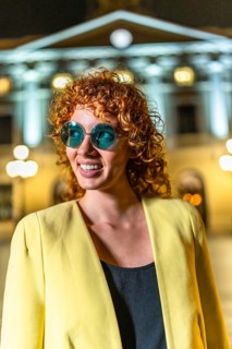 Vertical photo of a cool beauty woman with sunglasses looking aside standing in the city at night