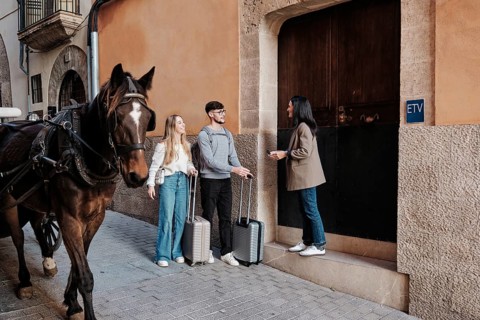 A young couple arrives with suitcases to explore their vacation home in Majorca, Spain. A woman