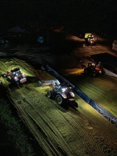 Several tractors working at night with headlights on a rural field, maize harvest, Dachtel, Black
