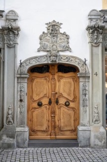 Magnificent wood-carved baroque door with decorative stone figures and intricate ornament in the