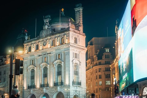 Illuminated historic buildings with large display board at night in London, New Year's Eve London,