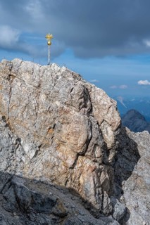 Golden summit cross on the rocky summit of the Zugspitze, Wetterstein range, Bavaria, Germany