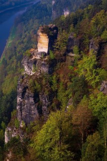 The bright lit Wartturm above the Elbe river seen from the Bastei rocks near the village of Rathen
