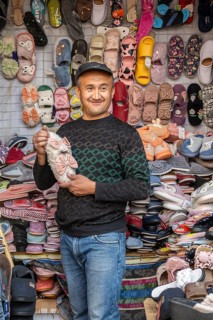 Man selling shoes, many different shoes, market stall at Osh bazaar, Bishkek, Kyrgyzstan