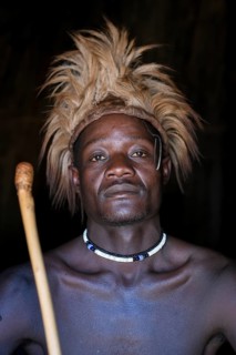 Young Himba man in his hut, Ohandungu, Kunene region, Kaokoveld, Namibia