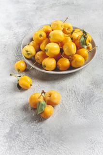 Yellow small apples, Chinese variety, on a gray plate, top view, no people