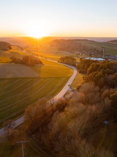Landscape with winding road at sunset, fields and forests in soft light, Calw, Black Forest,
