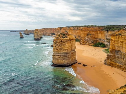 Stunning coastal cliffs and rock stacks rise dramatically from the ocean, set against a backdrop of