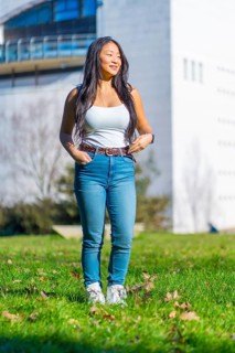 Vertical photo of a chinese cool student standing on the grass of the campus