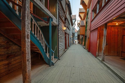 Summer day exploring behind facades in Bryggen Bergen, narrow lanes, colorful wooden buildings,