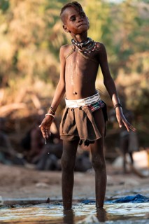 Himba child washing with water on a river, traditional Himba, Kaokoveld, Kunene, Namibia