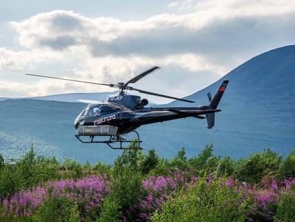 Helicopter picking up tourists at a parking lot near Nikkaluokta, flight to Kebnekaise base camp at