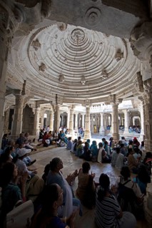 Indian woman praying between the white marble pillars in the Adinath temple in Ranakpur, Jain
