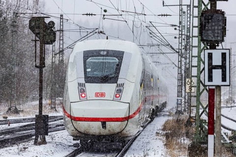 ICE traveling through a winter landscape in snowfall. A train on the line in the Deutsche Bahn
