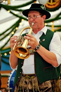 Musician of a Bavarian brass band in traditional traditional costume with lederhosen playing