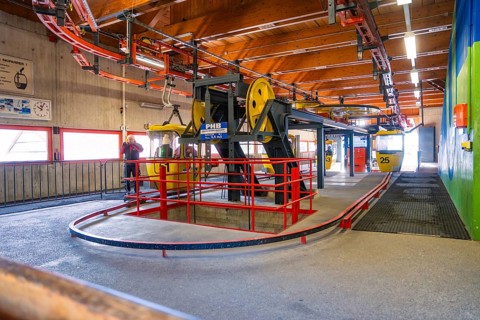 Interior view of a cable car station with yellow cabin and colorful walls, Hochgrat Mountains,